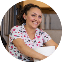 smiling housekeeper carrying cleaning supplies